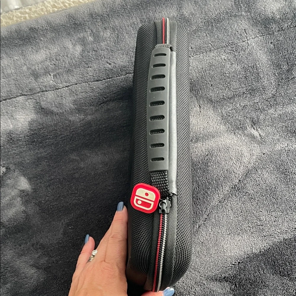 Nintendo Switch Black case with red and light grey accent stitching.