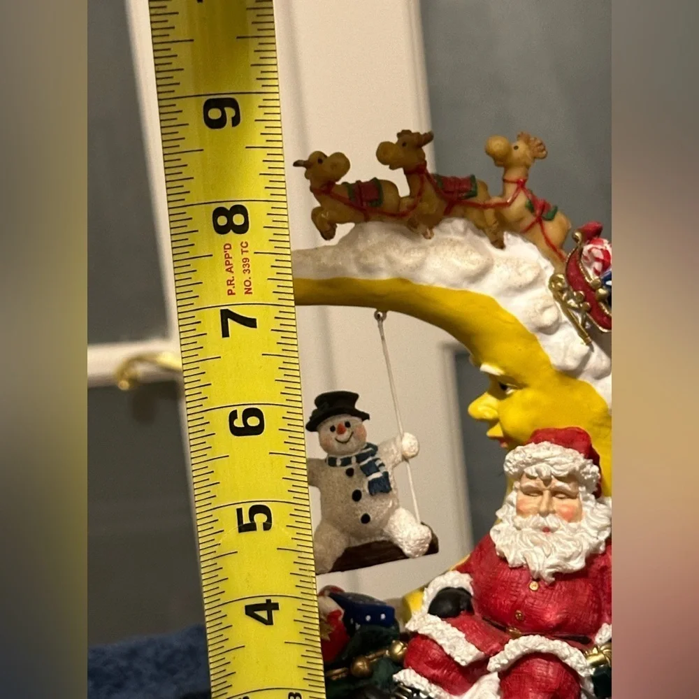Sleepy Santa rests while a snow buddy swings. Missing bottom