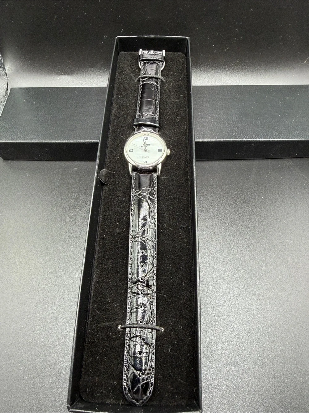 Aria quartz watch with leather strap. New in box but needs new battery.