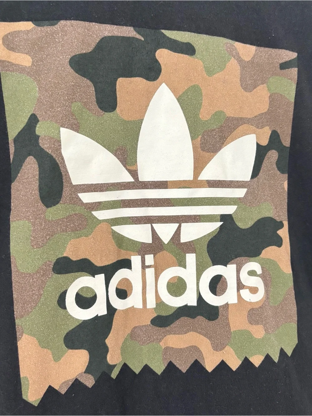 Adidas black t-shirt with white Adidas logo on camouflage background
