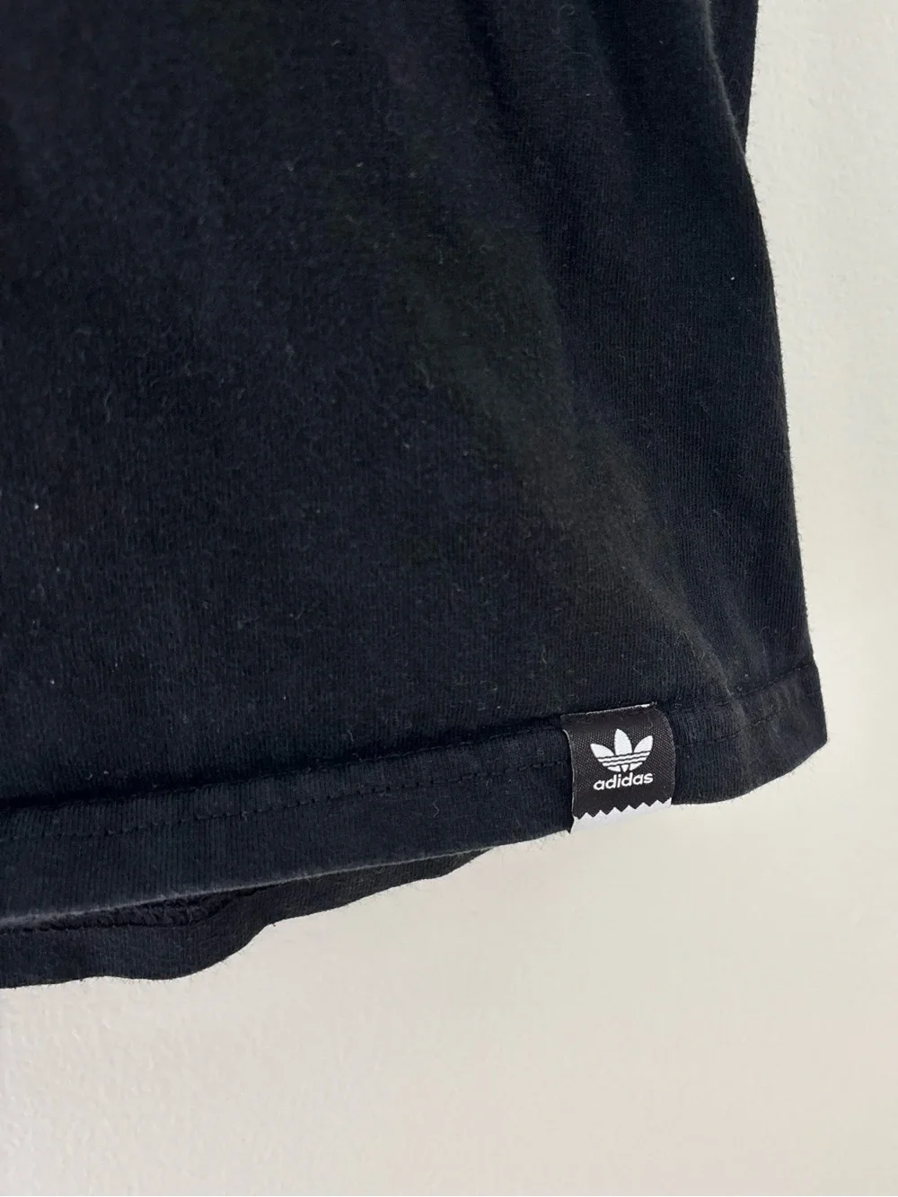 Adidas black t-shirt with white Adidas logo on camouflage background