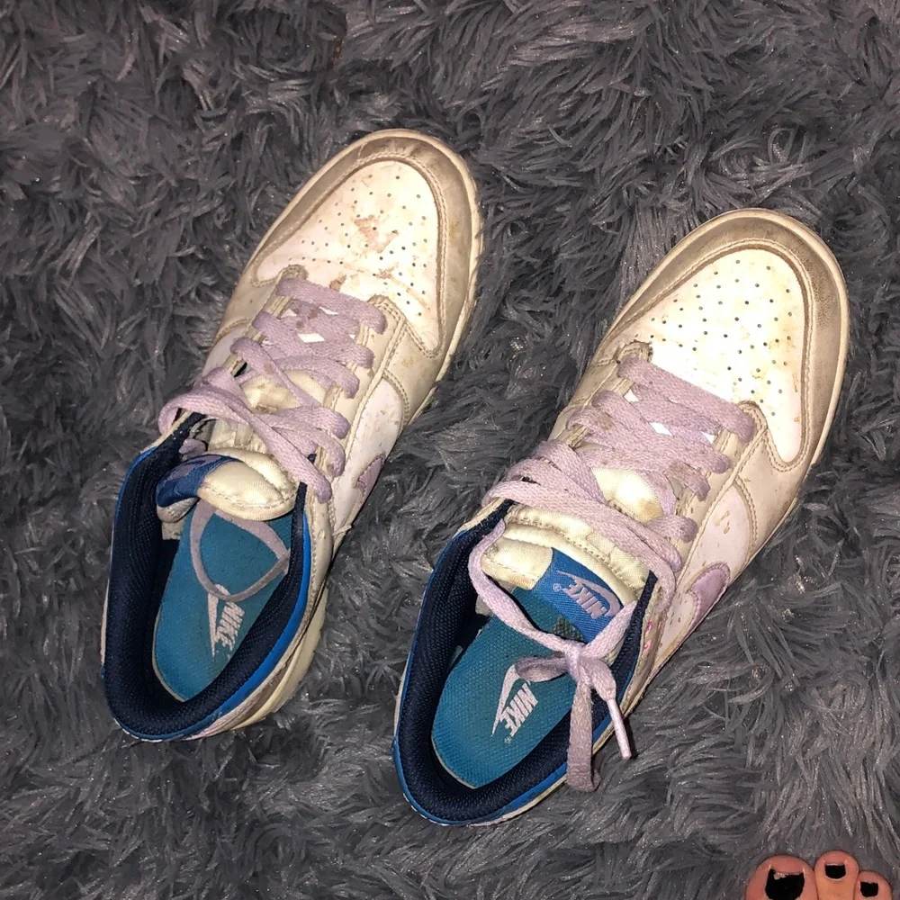 Well worn women’s Nike White dunks sneakers with Light Purple Accents WW