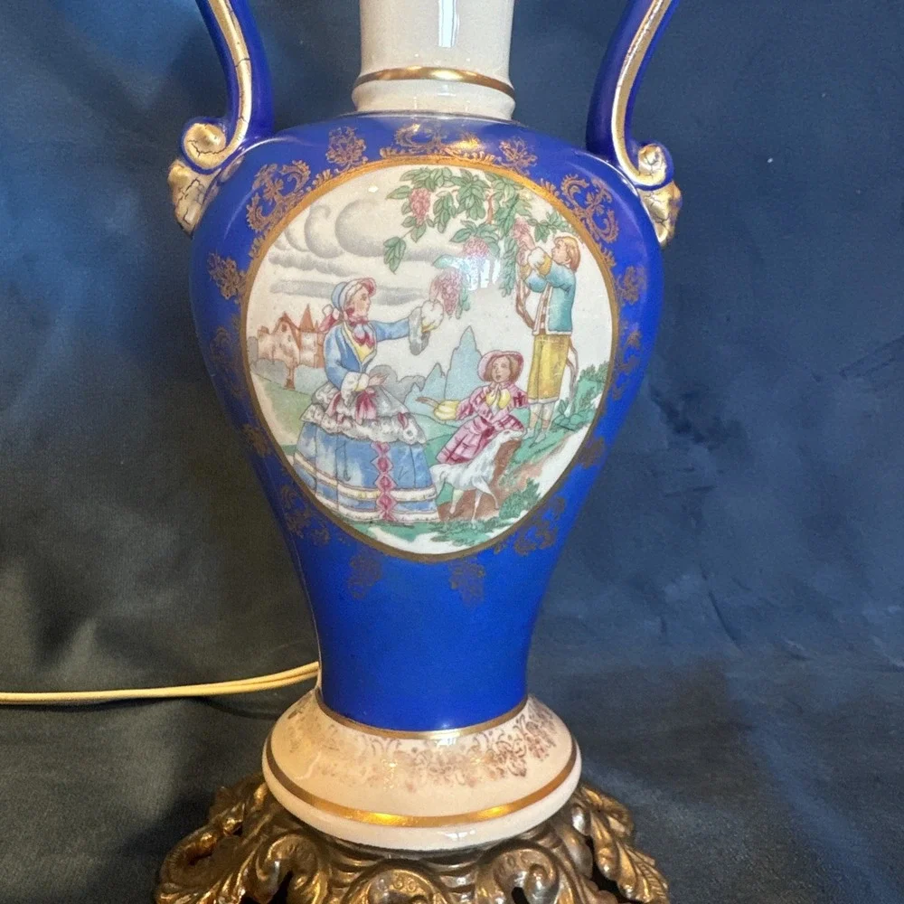 Antique porcelain urn lamp with grape-picking scene.