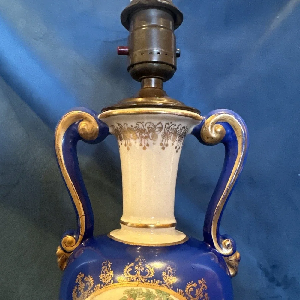 Antique porcelain urn lamp with grape-picking scene.