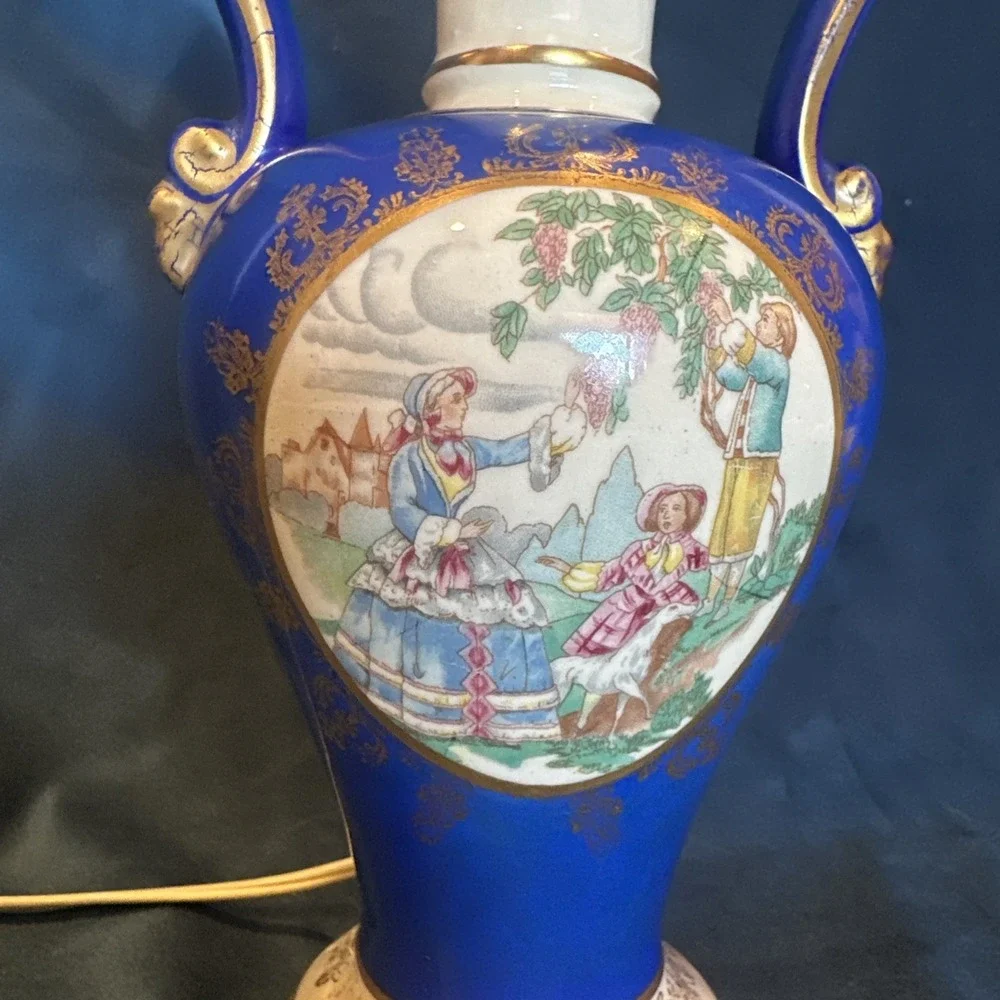 Antique porcelain urn lamp with grape-picking scene.