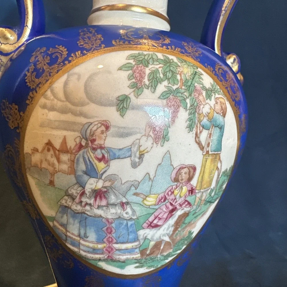 Antique porcelain urn lamp with grape-picking scene.