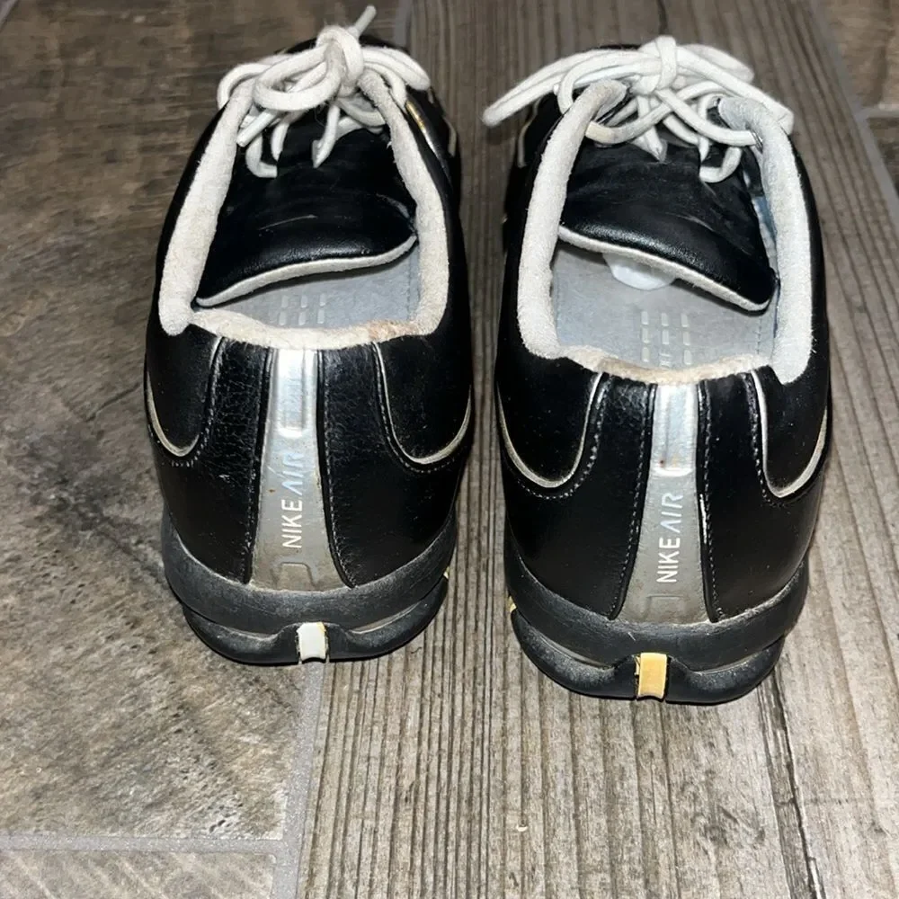 Nike Air TAC black leather golf shoes, sports performance.