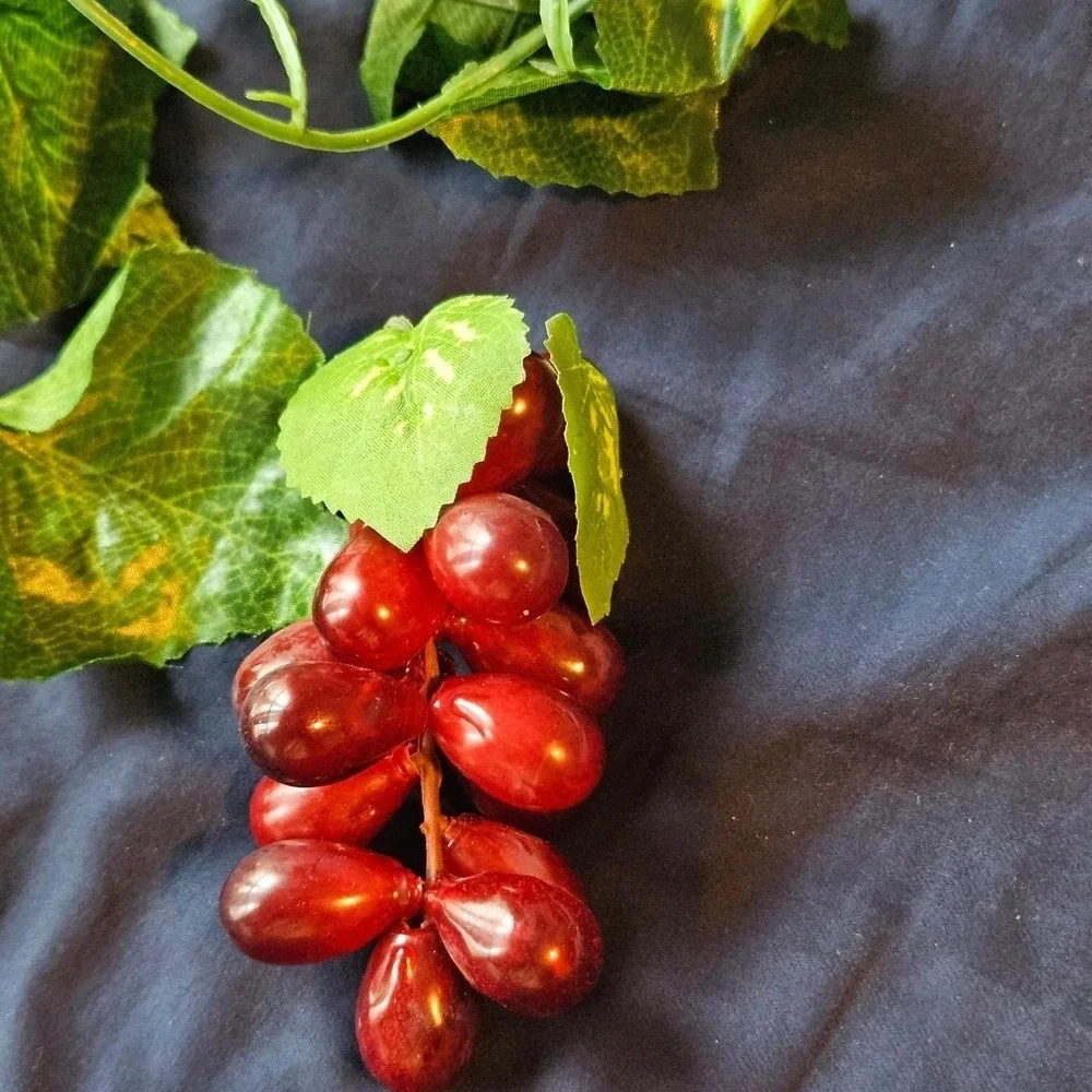 Red plastic grape cluster with green leaves