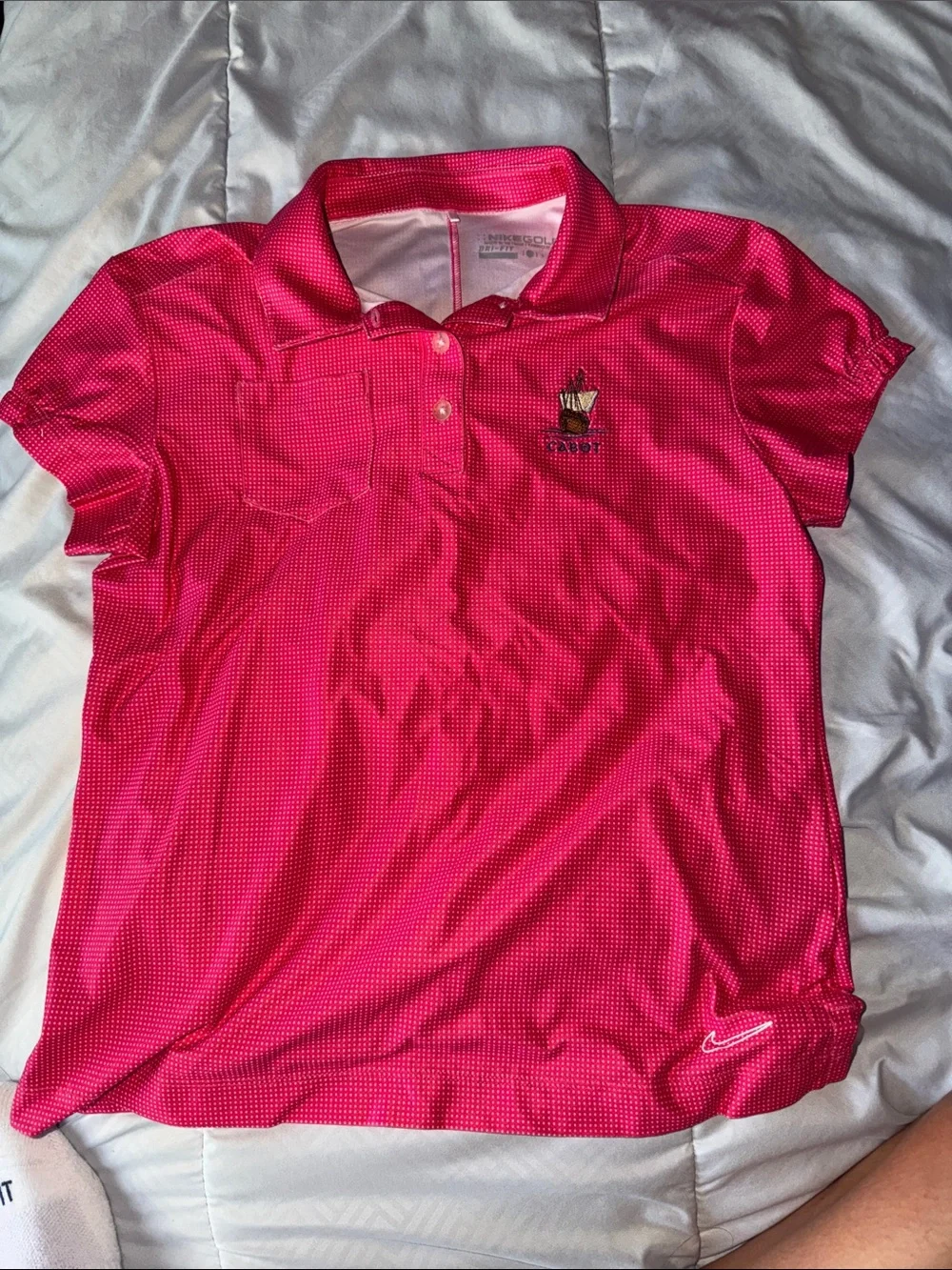 Pink/white polka-dotted Nike Golf Dri-FIT polo ship logo 