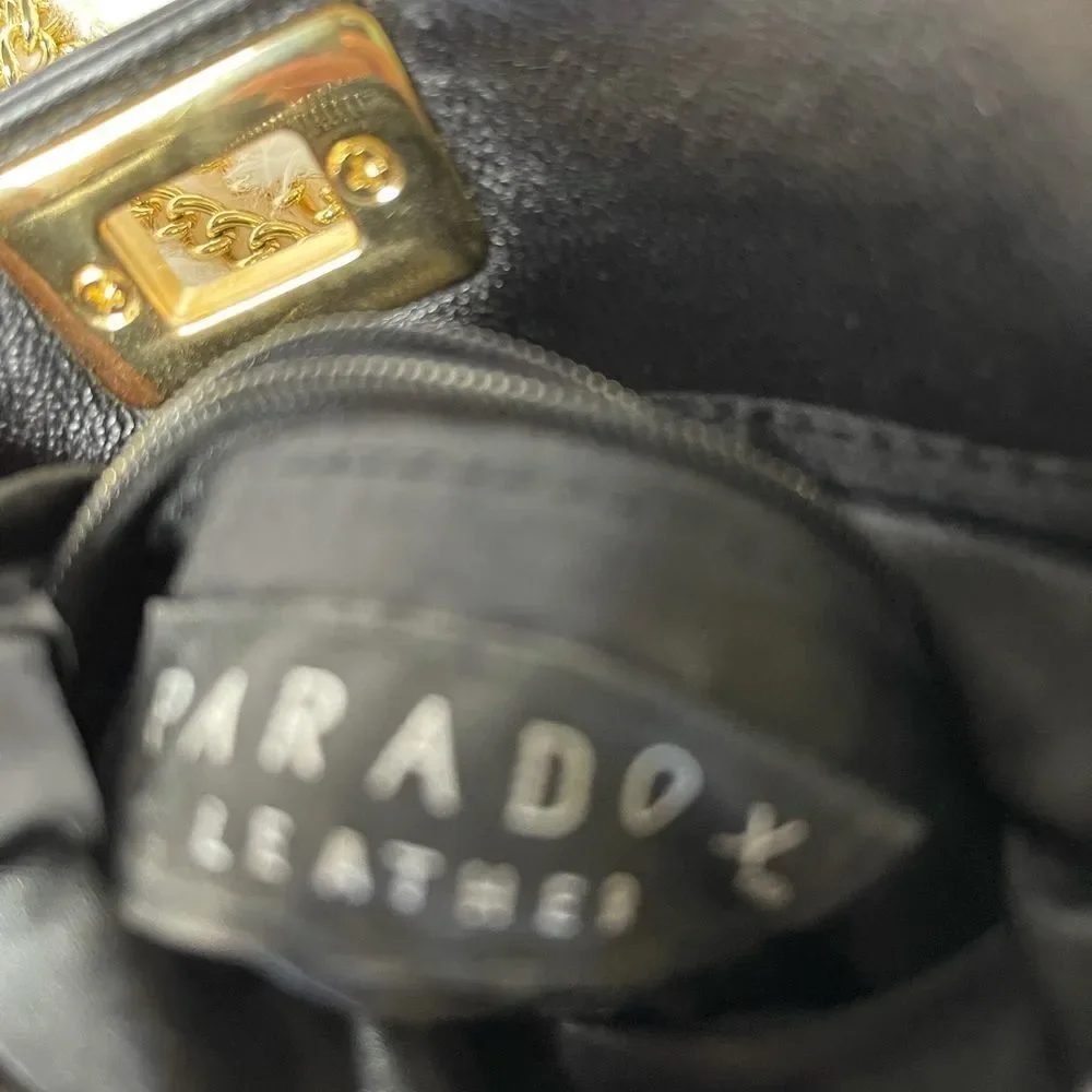 Paradox leather black small crossbody bag with ajustable gold tone chain.