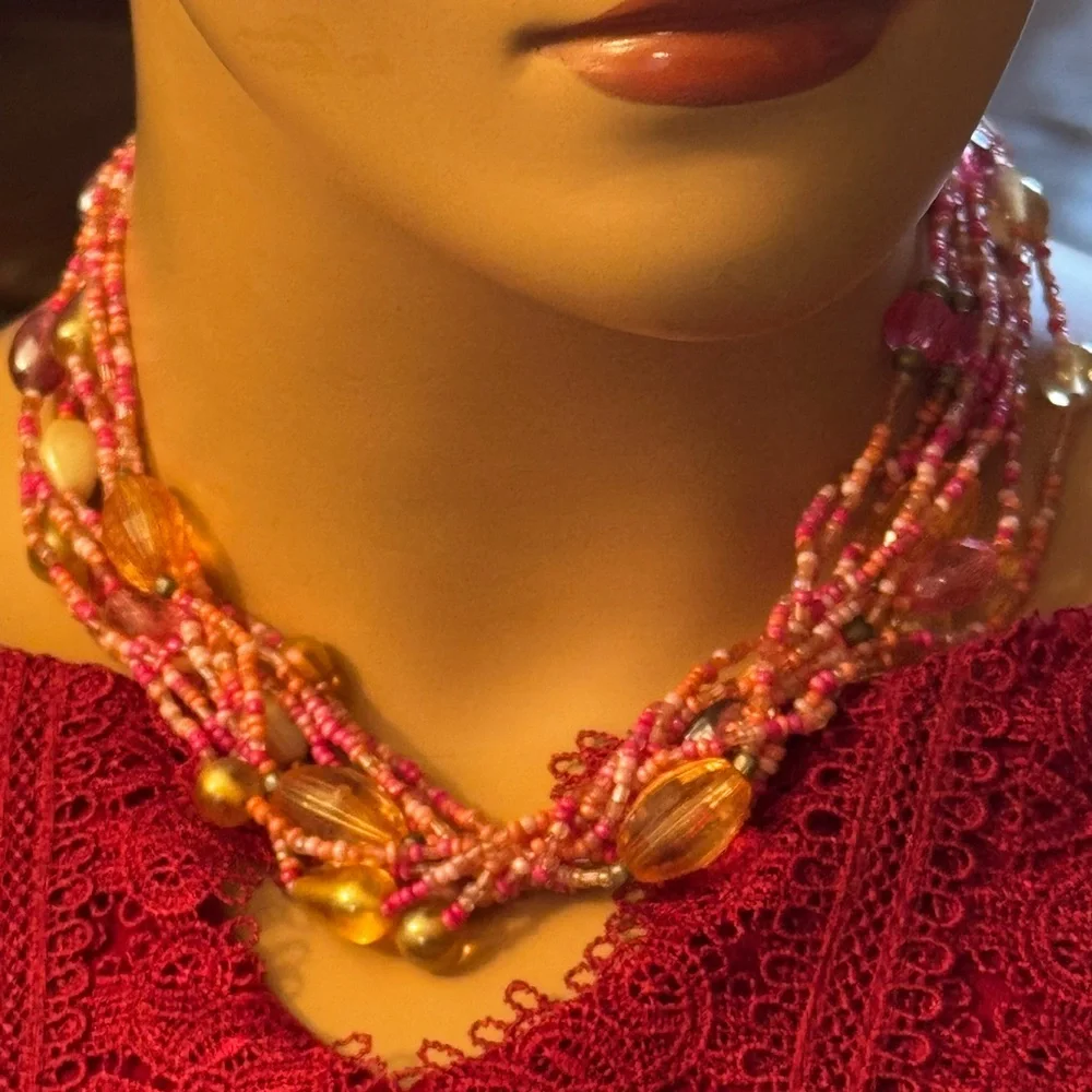Multi strand torsade style necklace w/coral,pink and salmon colored seed beads
