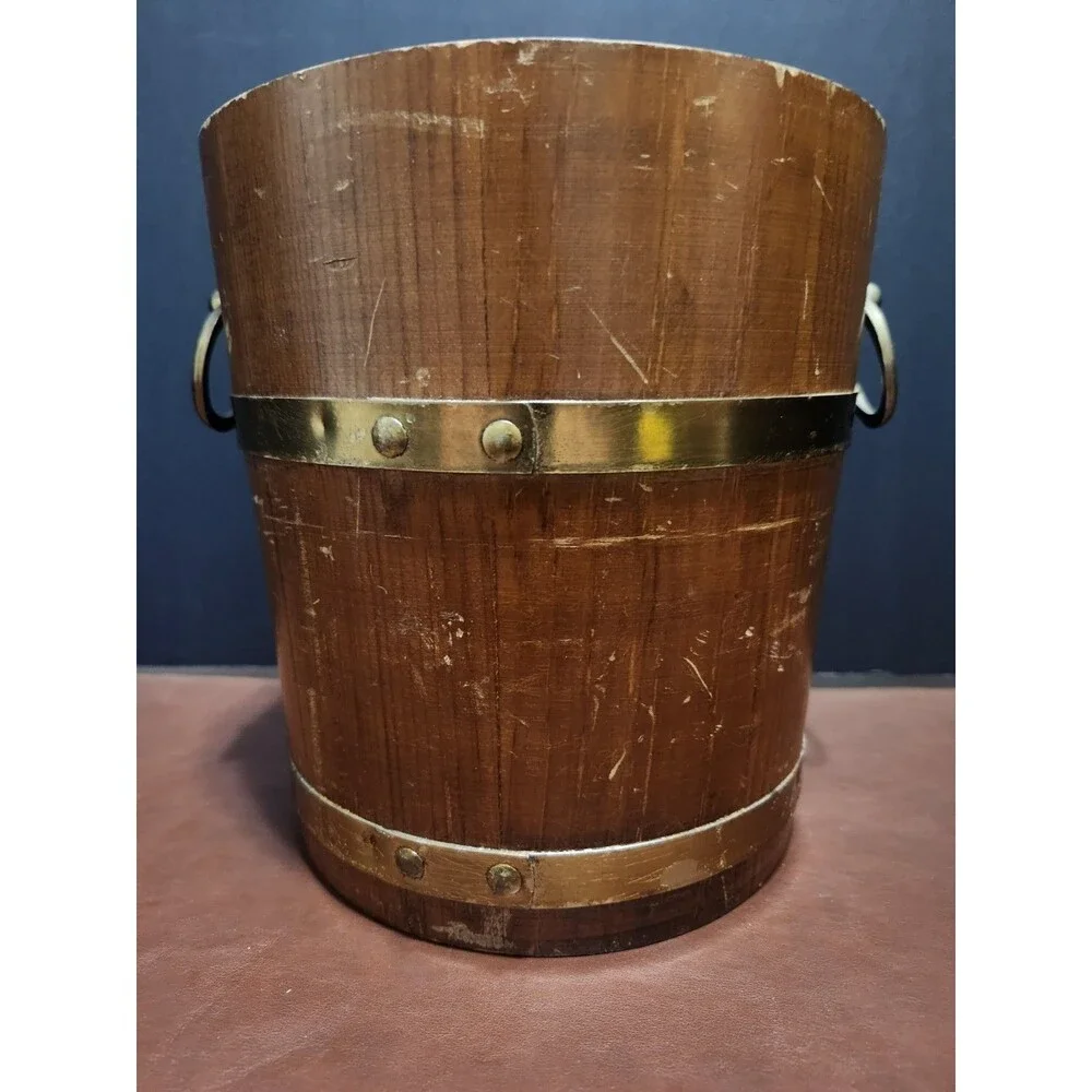 This is a vintage wood and brass barrel-style ice bucket typically measuring...
