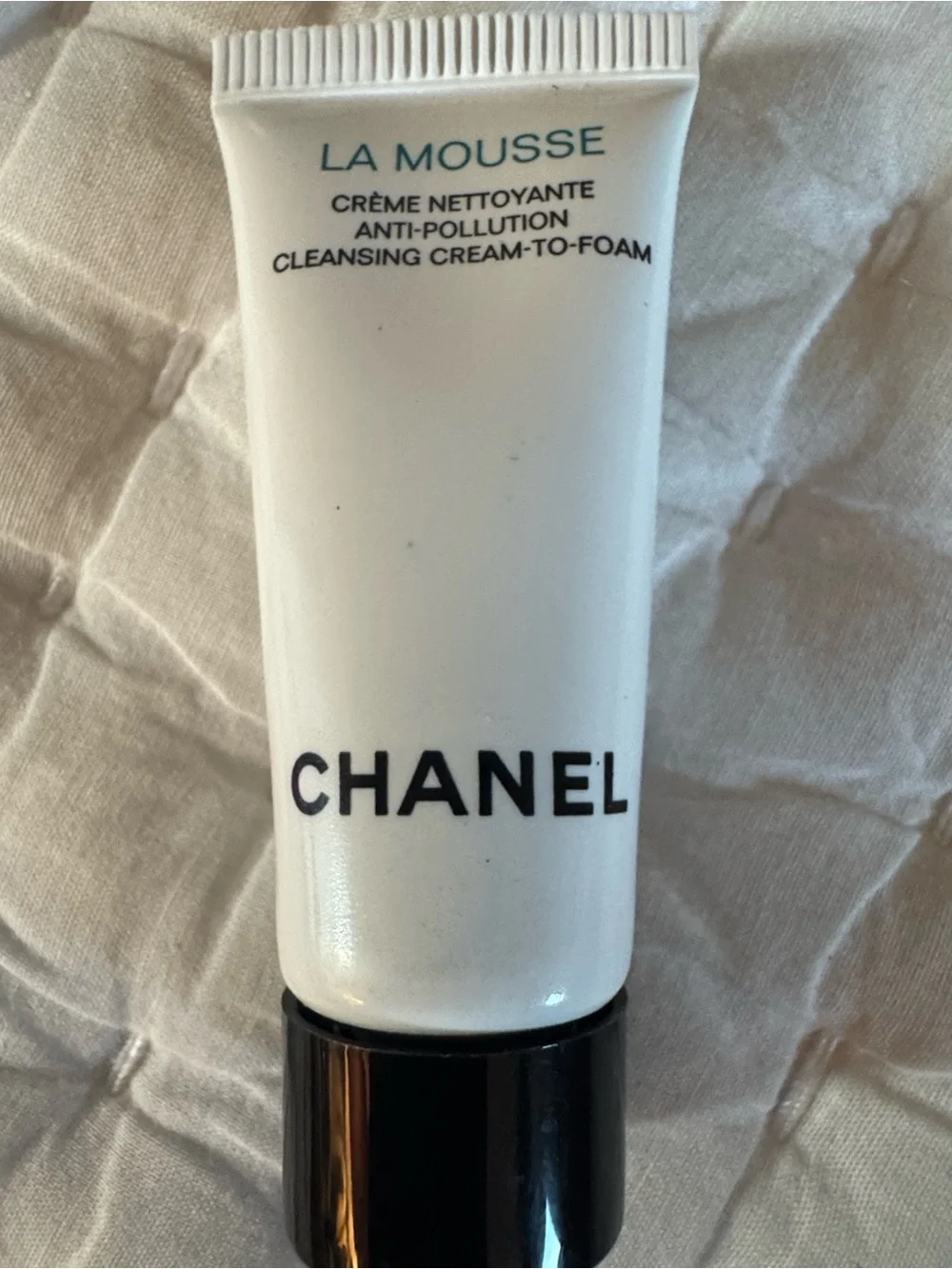 CHANEL Beauté Black and Cream Makeup Pouch and skincare products.