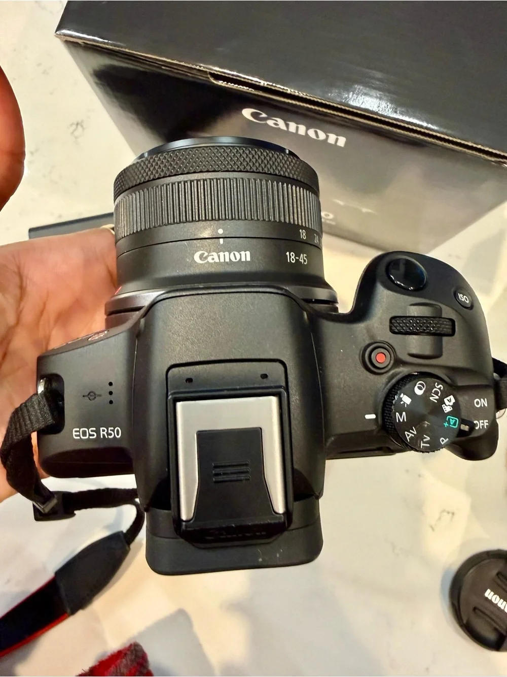 Canon EOS R50 Black Mirrorless Camera with Red-Trim Strap and Green Case